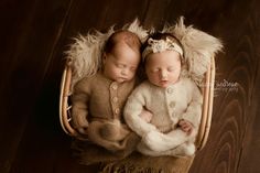 two babies are sleeping together in a basket