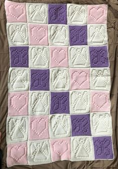 a crocheted blanket with hearts on it