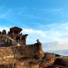 an old building on the edge of a cliff by the ocean