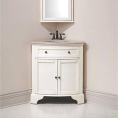 a white bathroom vanity with a mirror above it