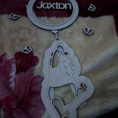 a wooden keychain with the name ajaxton hanging from it's center