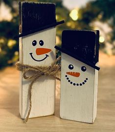 two snowmen made out of popsicle sticks on a table