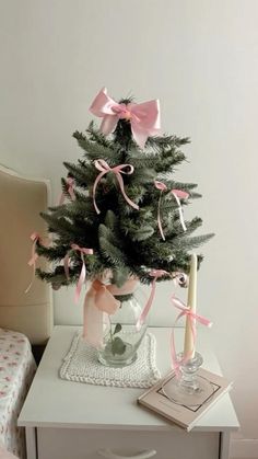 a small christmas tree with pink bows on it