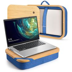 an open laptop computer sitting on top of a wooden desk next to a blue case