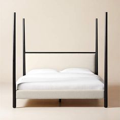 a bed with white sheets and black frame