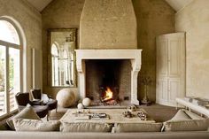 a living room filled with furniture and a fire place in the middle of the room