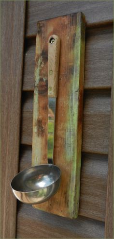 a spoon hanging on the side of a wooden wall