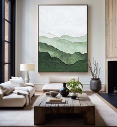 a living room filled with furniture and a large painting hanging on the wall over a fire place