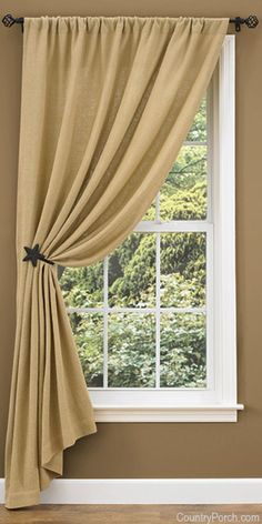 an open window with curtains hanging on the side and a photo frame in front of it