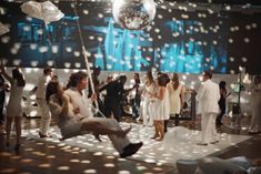 a group of people standing and sitting in front of a disco ball