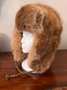 Experience ultimate luxury with our handmade Baby Alpaca Fur Trapper Hat. Crafted in the Andes region of Peru, this hat feels like a cozy cloud hugging your head. Perfect for outdoor activities like hiking, hunting, or living off-grid, it’s loved by hunters for its exceptional warmth—warmer than polar bear fur—while also regulating heat. Stay comfortable without overheating, as it adjusts to keep you warm when needed and cool when it’s not. The hypoallergenic baby alpaca fur on this Alpaca Fur T Alpaca Hat For Outdoor Winter Use, Winter Outdoor Alpaca Hat, Warm Brown Hats For Outdoor Activities, Brown Hats With Ear Flaps For Outdoors, Warm Brown Hat For Outdoor Activities, Brown Hats With Ear Flaps For Outdoor Activities, Sheepskin Hats With Ear Flaps For Outdoor, Sheepskin Outdoor Hat With Ear Flaps, Adjustable Alpaca Hat For Outdoor