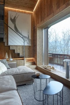 a living room filled with furniture next to a large open window covered in wood paneling