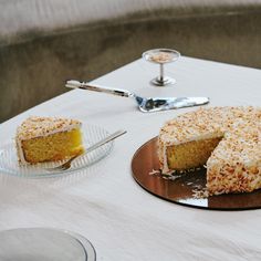 a cake sitting on top of a table next to a plate with a slice missing