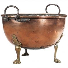 an old metal bowl with two handles on it's legs and feet in front of a white background