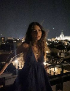 a woman standing on top of a roof at night