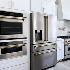 a kitchen with stainless steel appliances and white cabinets, including stoves and ovens