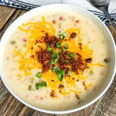 a bowl of soup with cheese and green onions