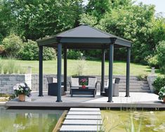 a gazebo sitting on top of a wooden deck next to a pond