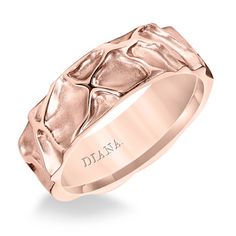 a rose gold wedding ring with an intricate design on the center and engraving in the middle