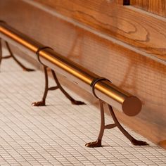 a close up of a wooden bench on tiled floor