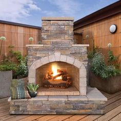 an outdoor fireplace in the middle of a wooden deck