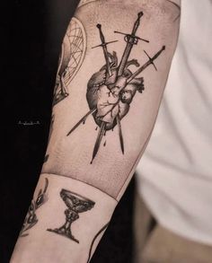 a man's arm with tattoos on it, including two crossed swords and a heart