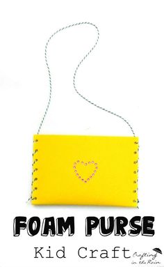 a yellow purse with a heart drawn on the front and side, hanging from a string