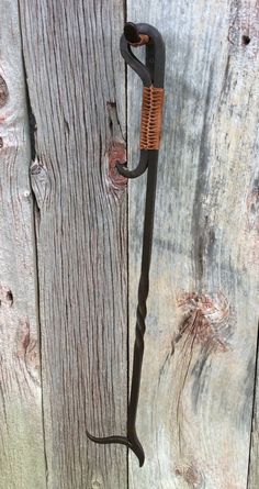 an umbrella is hanging on the side of a wooden fence with rusted metal handles