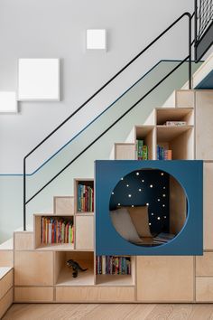 a room with bookshelves, stairs and a book case in the shape of a moon