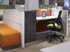 an office cubicle with desk, chair and laptop on the computer screen in front of it