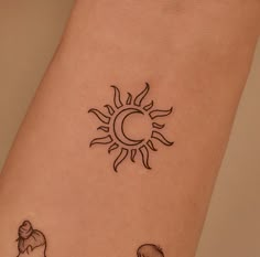 a woman's arm with two small tattoos on it, and the sun behind her