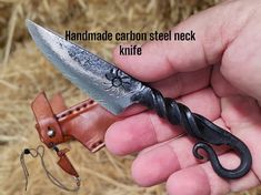 a person holding a knife in their hand with the words handmade carbon steel neck knife