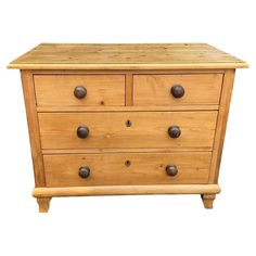 a wooden dresser with three drawers and two knobs on the front, against a white background