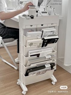 a person sitting at a desk with many items in the drawer on top of it