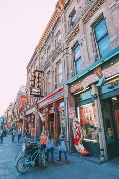 people are walking down the street in front of shops