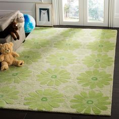 two teddy bears sitting on a bench in front of a rug that has flowers on it