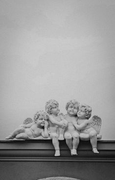 three cherubs sitting on top of a building