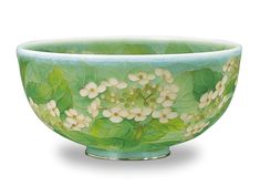 a green bowl with flowers and leaves painted on it