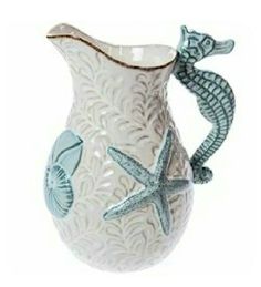 a white and blue ceramic vase with seahorses on the side, holding a starfish