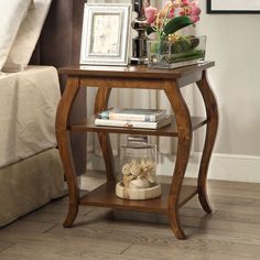 a small wooden table with flowers and books on it