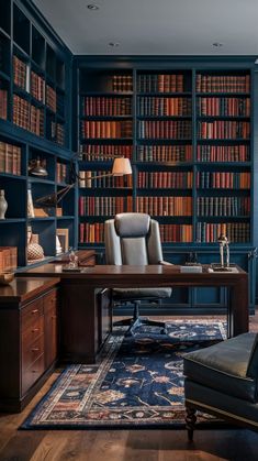 an office with blue walls and lots of bookshelves in the room, along with a leather chair