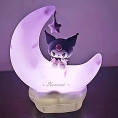 a small figurine sitting on top of a moon shaped light up display case