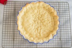 an uncooked pie sitting on top of a cooling rack next to a red pepper