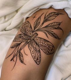 a black and white photo of a woman's leg with tattoos on it