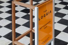 an orange sign sitting on top of a black and white checkerboard tile floor