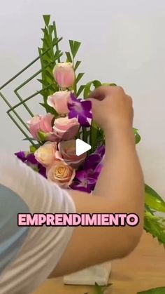 a person arranging flowers on top of a table with the words empreendimiento