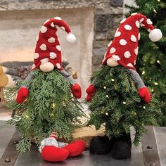 two gnomes sitting on top of christmas trees