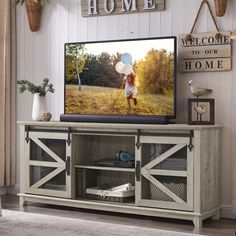 a flat screen tv sitting on top of a wooden cabinet