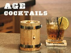 an old fashioned wooden beverage dispenser next to a glass filled with ice