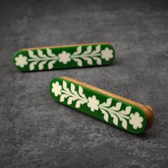 two green and white wooden objects on the ground